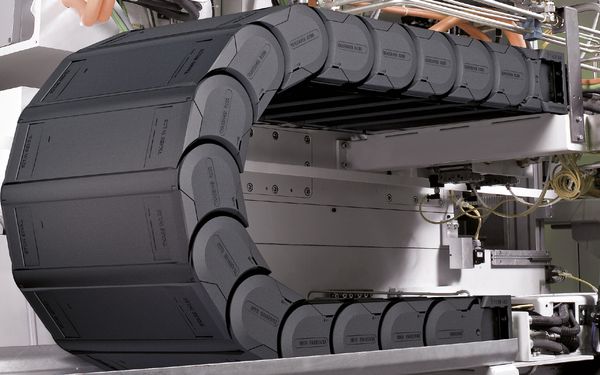 Een Tsubaki Kabelschlepp kabelrups in een industriële toepassing met flexibele kabels.