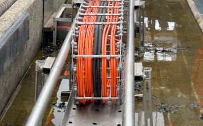 Gedetailleerde foto van de gereviseerde roestvrijstalen kabelrups van de Maeslantkering, met zicht op de robuuste constructie en de omgeving van de kering.