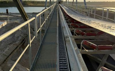Close-up van een robuuste Tsubaki Kabelschlepp kabelrups in een industriële omgeving, met kabels die erdoorheen lopen.